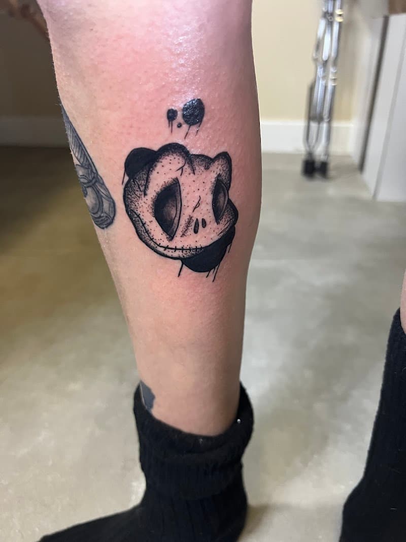 Blackwork tattoo van een gestileerde, duistere karakter kop met dotwork.