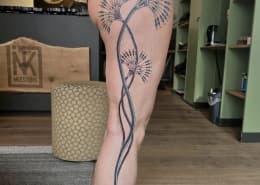 Grote fineline paardenbloem tattoo op het bovenbeen.