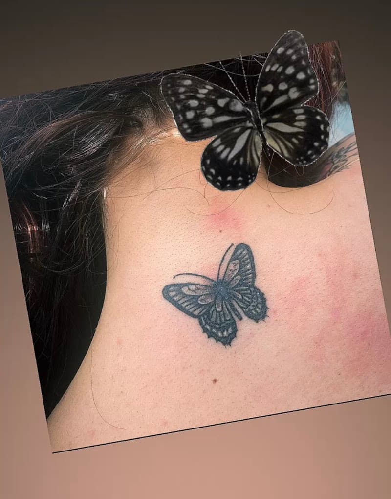 Kleine fineline vlinder tattoo in de nek.