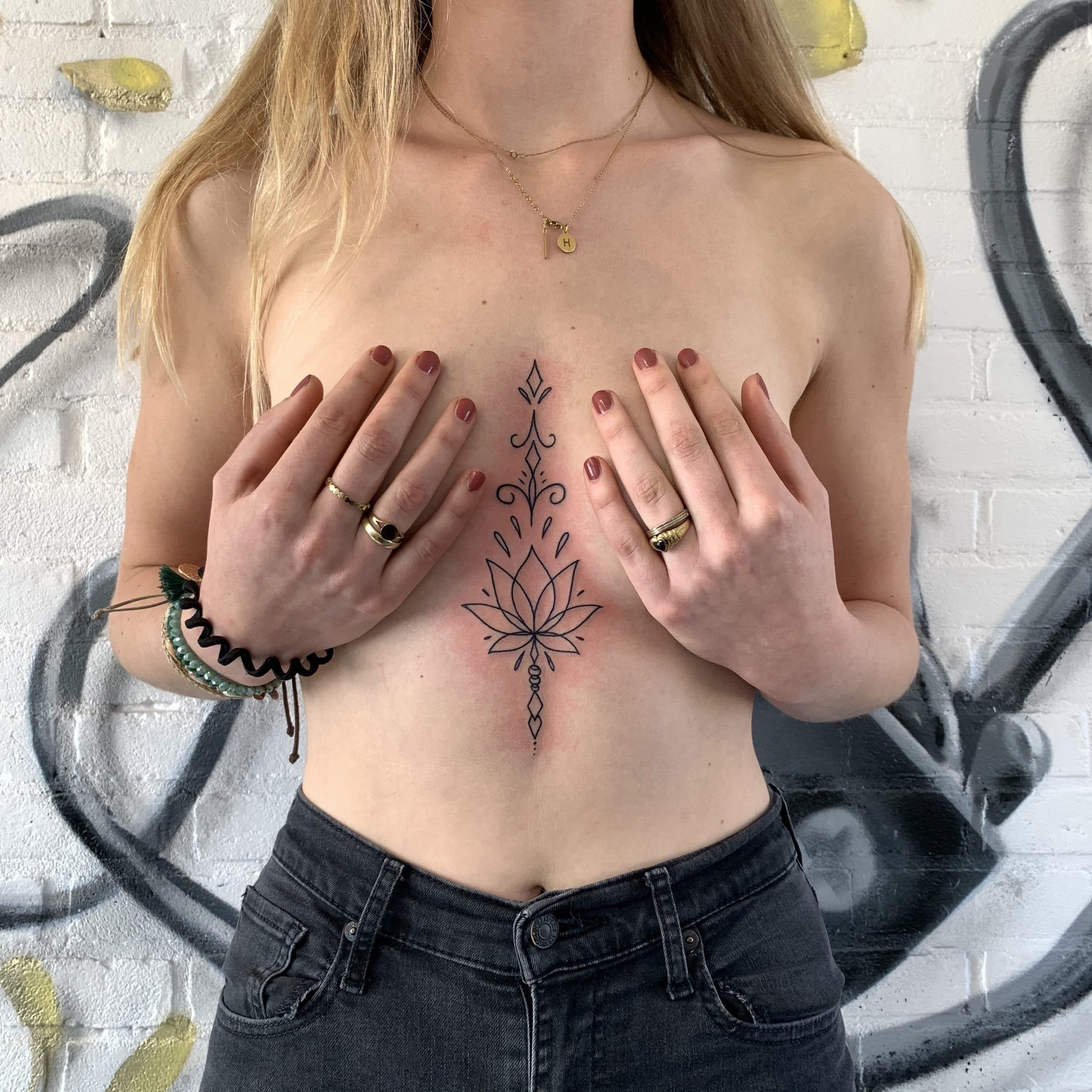 Fineline lotusbloem met ornamenten op het borstbeen.