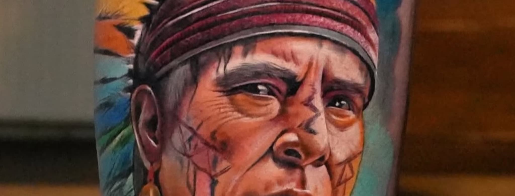 Realistisch kleurenportret van een inheemse man met hoofdtooi.