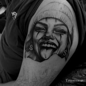 Realistisch portret van lachende vrouw met clownsmake-up en muts op bovenarm.