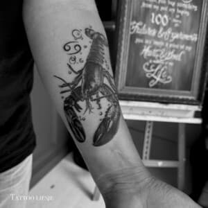 Realistische kreeft met Kreeft sterrenbeeld symbool op onderarm.