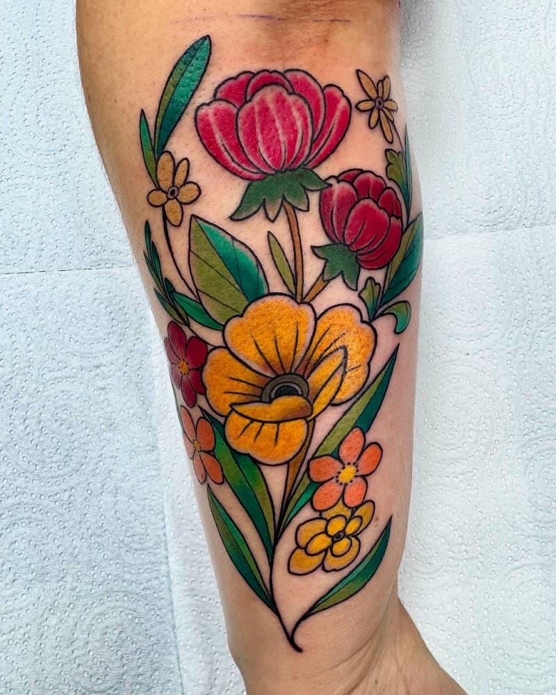 Kleurrijke bloemen tattoo in neo-traditional stijl op onderbeen.