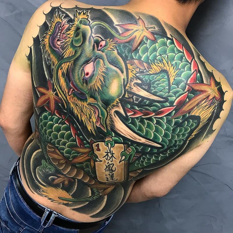 Grote Japanse draak full-back tattoo met esdoornbladeren en een houten bordje.