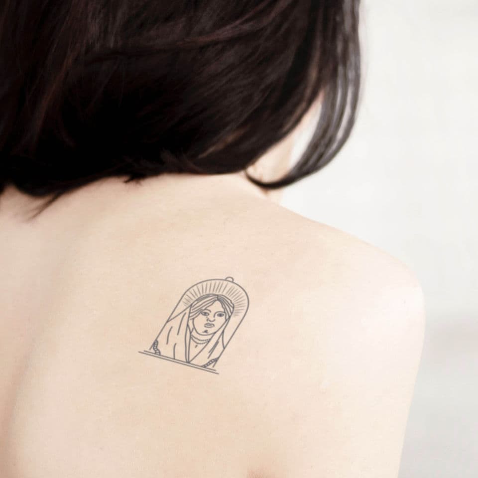 Minimalistische fineline tattoo van vrouw in stolp op schouder.