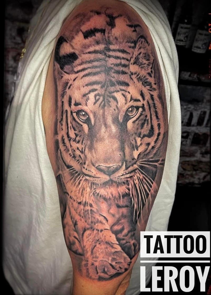 Realistische tijgerkop tattoo op bovenarm.