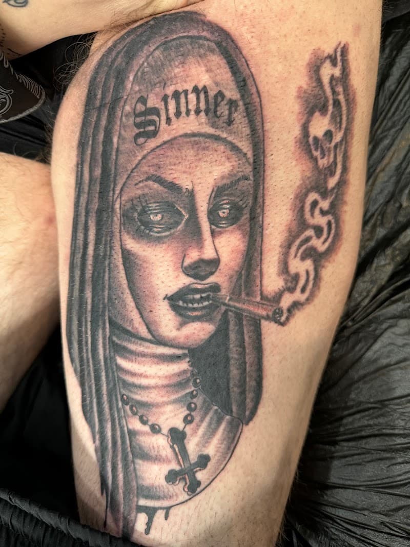 Zwart-wit tattoo van een rokende non met 'Sinner' tekst en een kruis.