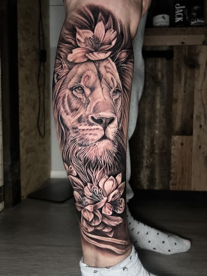 Realistische leeuw met bloemen op onderbeen.