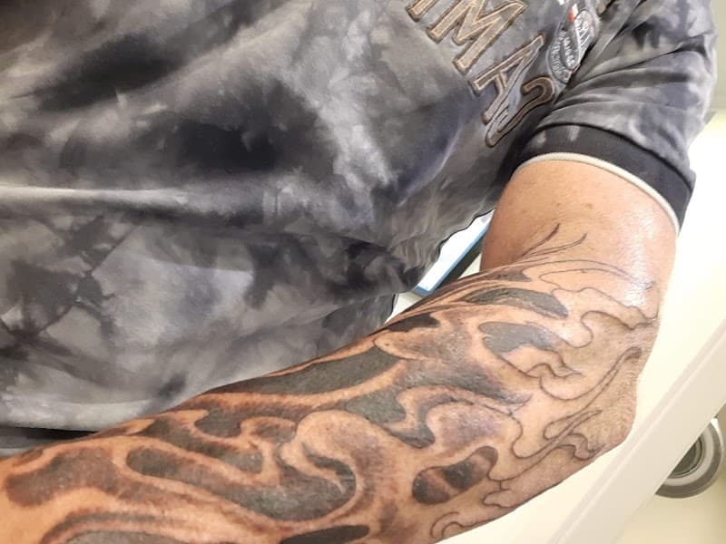 Zwart-wit tribal vlammen tattoo op onderarm.