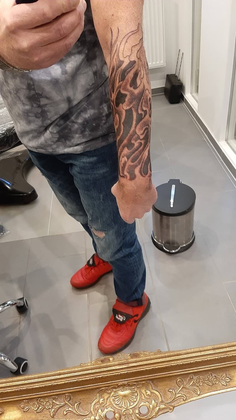 Zwart-grijze tribal vlammen tattoo op de onderarm.