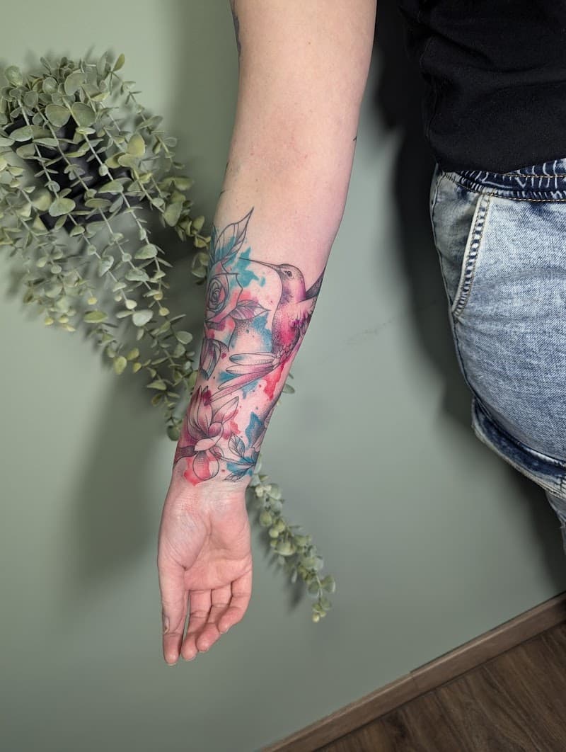 Watercolor kolibrie en bloemen op onderarm.