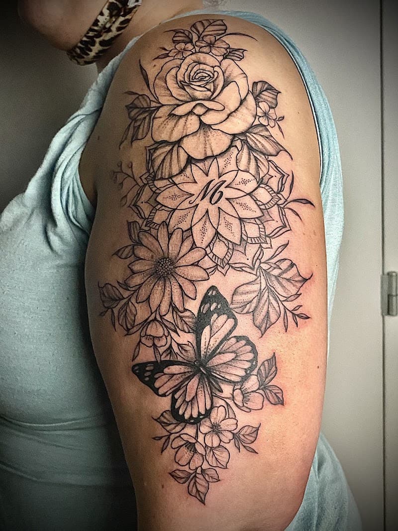 Zwart-wit bloemen, mandala en vlinder op bovenarm.