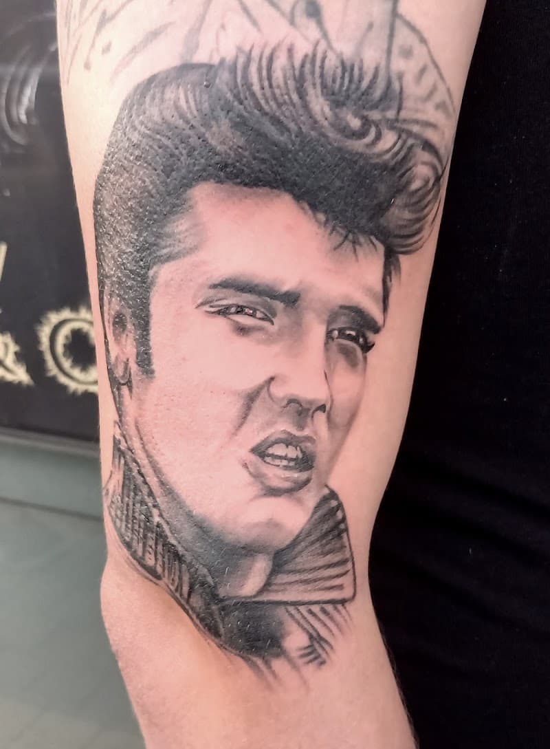 Realistisch zwart-wit portret van Elvis Presley op de bovenarm.