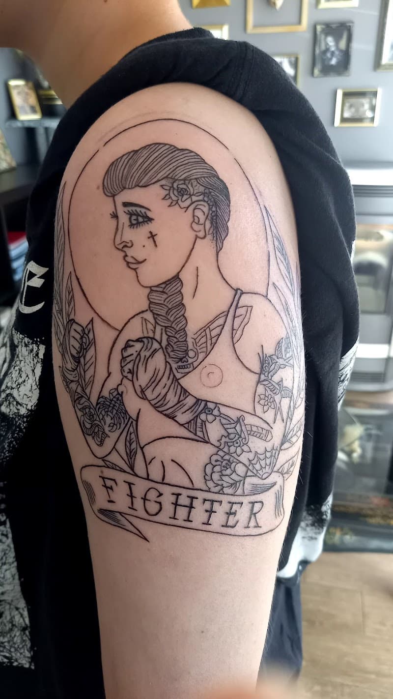 Lijnwerk tattoo van een vrouwelijke vechter met 'FIGHTER' banner op bovenarm.