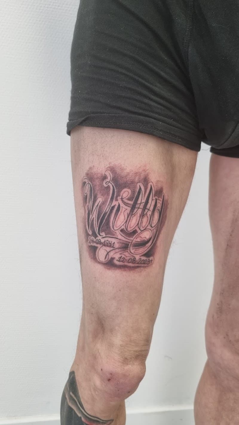 Herdenkingstattoo met naam "Willy" en datums op bovenbeen.