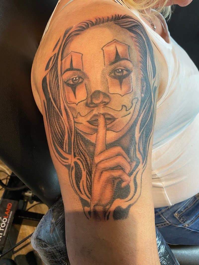 Chicano stijl tattoo van een vrouw met clownsmake-up die 'ssst' gebaar maakt.
