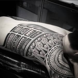 Grote Polynesische tribal tattoo op rug en schouder.