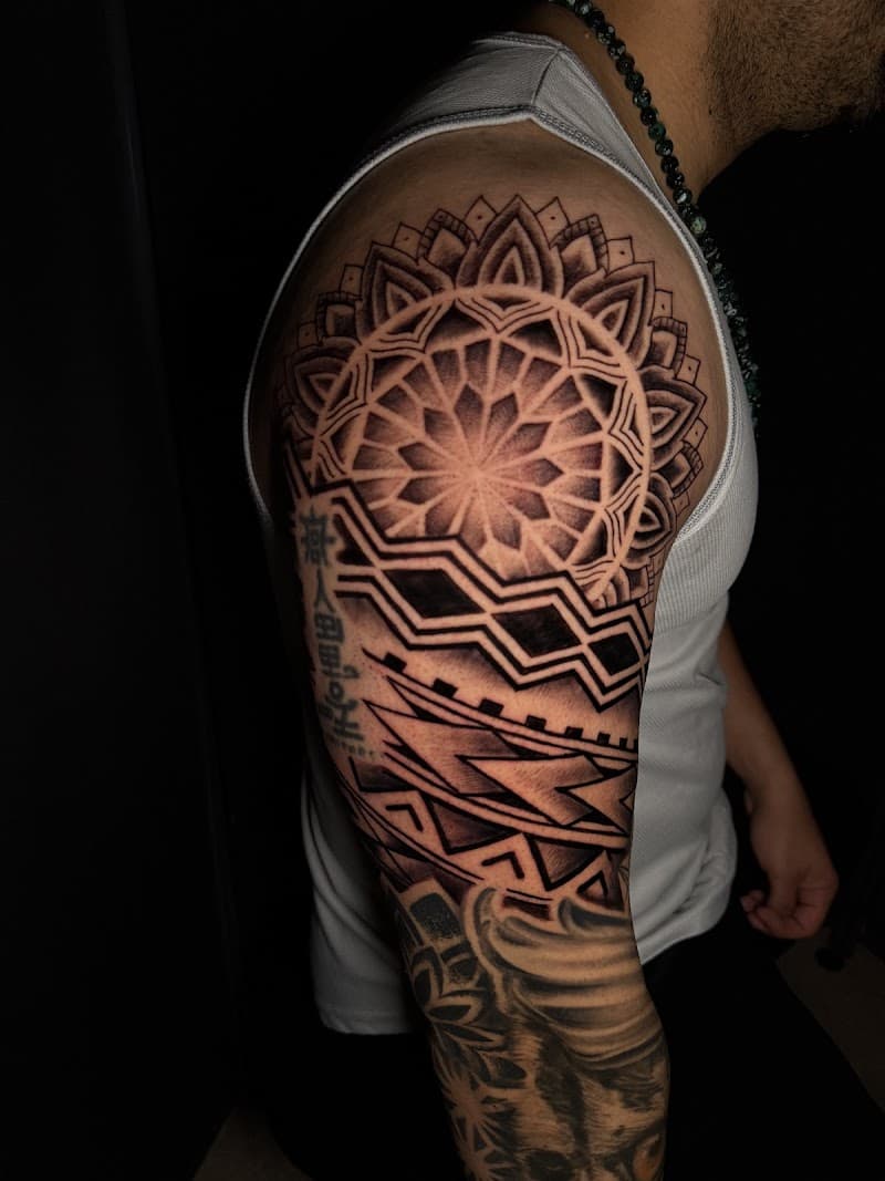 Grote mandala en geometrische patronen op schouder en bovenarm.