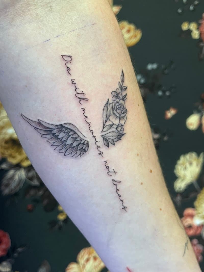 Fineline tattoo met tekst "Die with memories not dreams", vleugel en bloemen.
