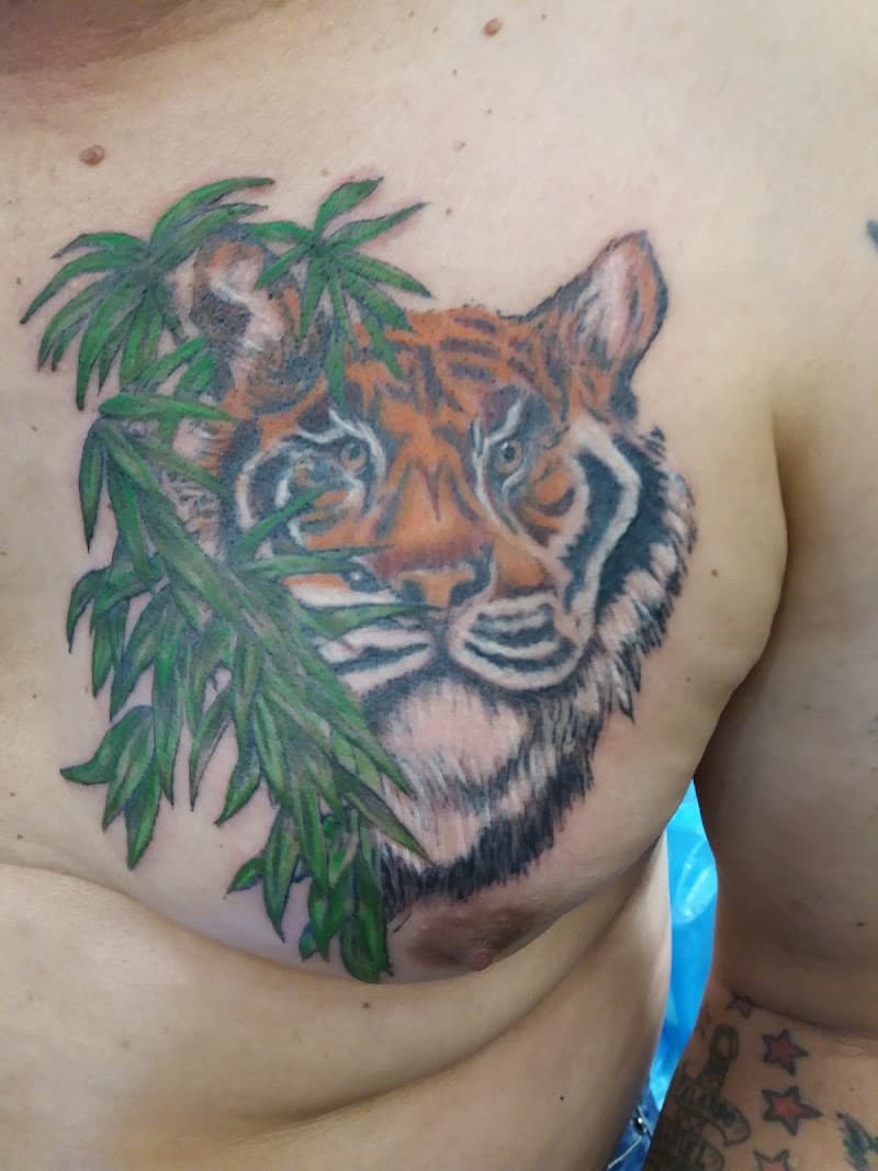 Kleurrijke tijgerkop met bamboe bladeren op de borst.