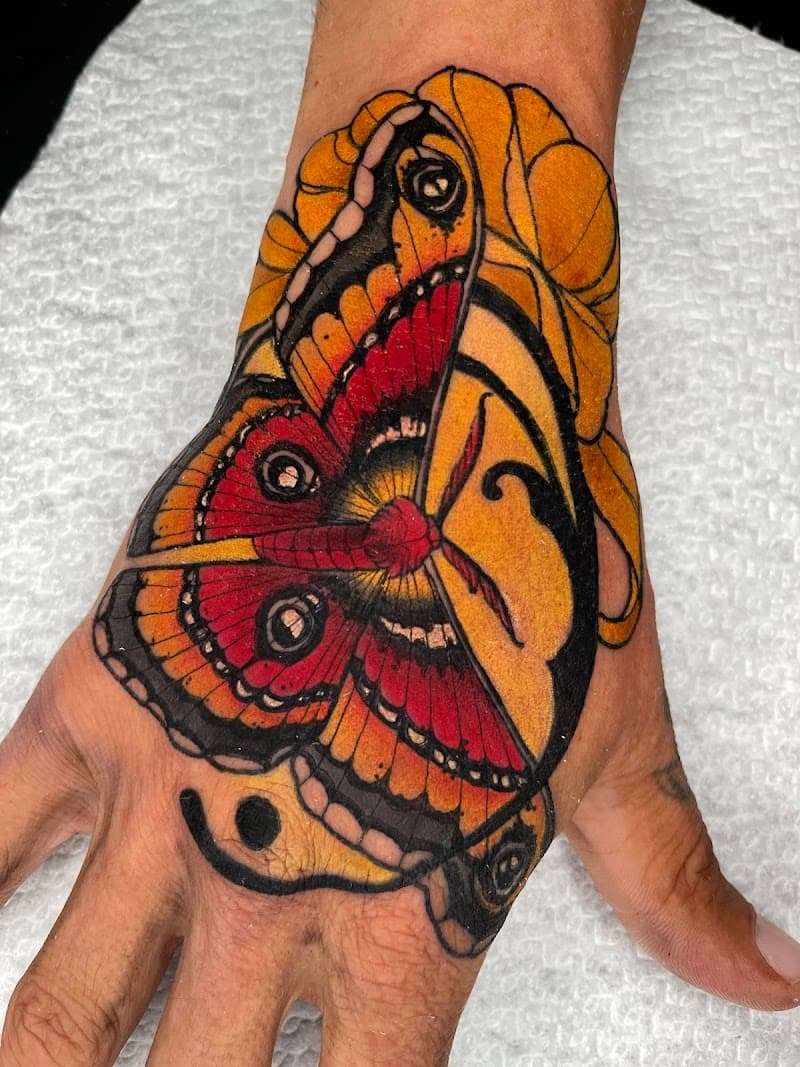 Neo-traditional mot met gezichtsprofiel op hand.