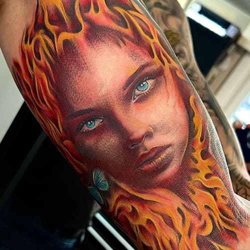 Realistisch portret van een vrouw met vlammend haar en een blauwe vlinder.