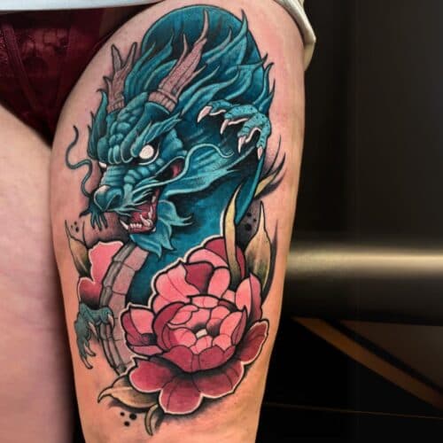 Neo-traditionele blauwe draak met roze pioenroos op bovenbeen.