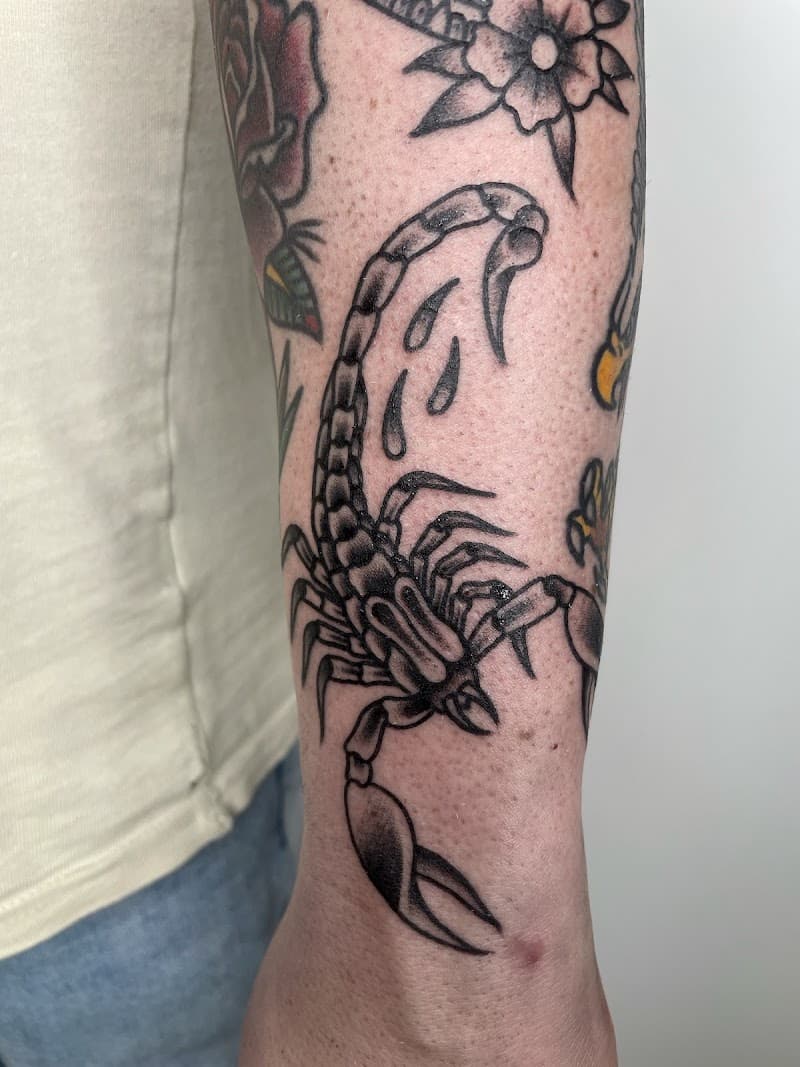 Zwart-witte traditionele schorpioen tattoo op de onderarm.