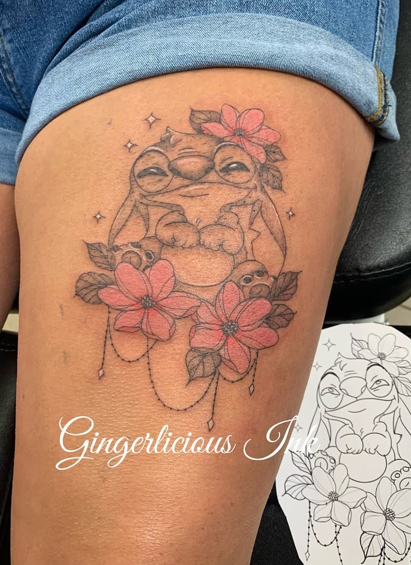 Schattige Stitch tattoo met roze bloemen en ornamenten op bovenbeen.