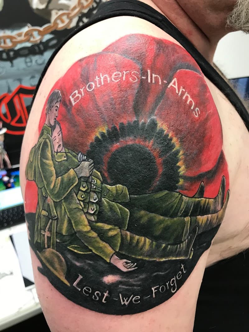Kleurrijke tattoo van twee soldaten en een klaproos met 'Brothers-In-Arms' tekst.