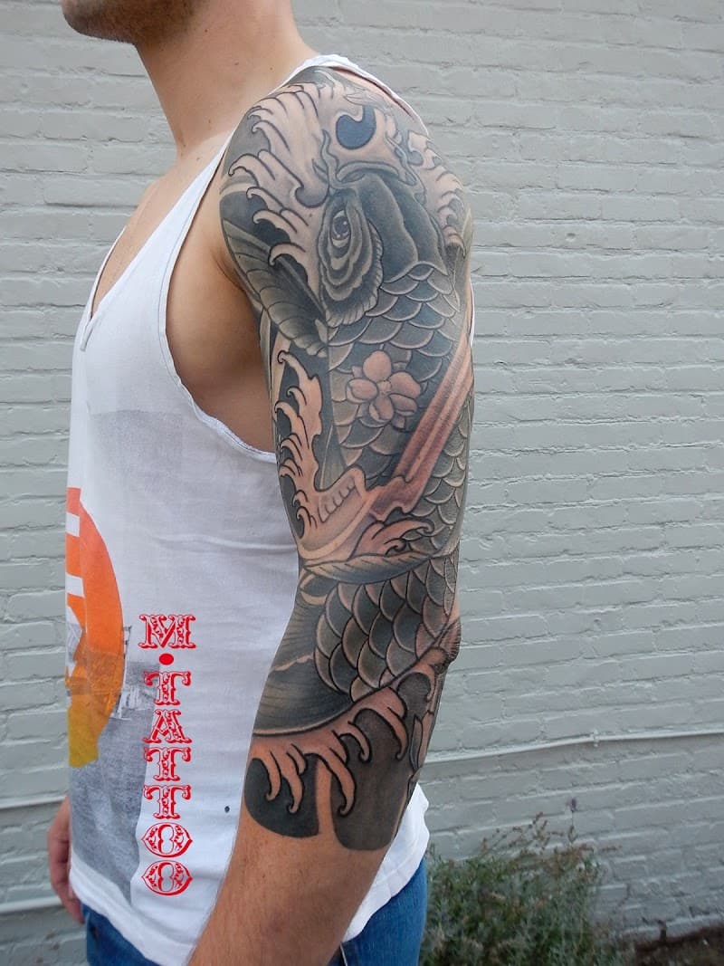 Grote Japanse koi karper tattoo op een volledige arm sleeve.