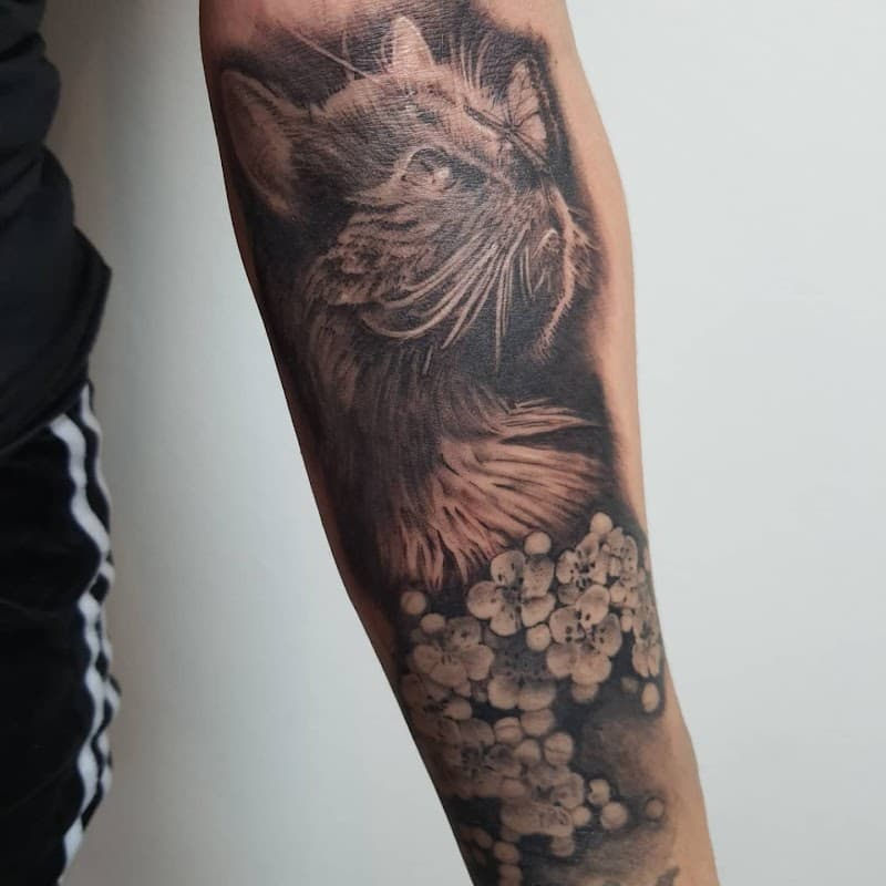 Realistische kat met vlinder en bloesem op onderarm.