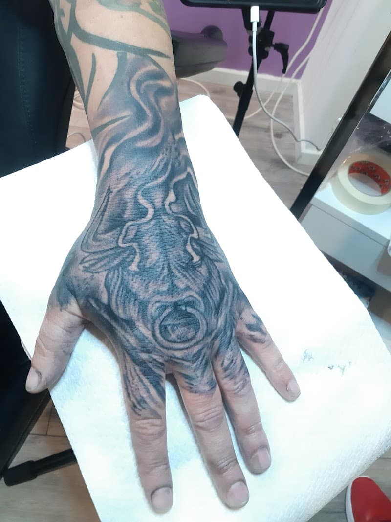 Abstracte blackwork tattoo op hand en vingers met organische vormen.