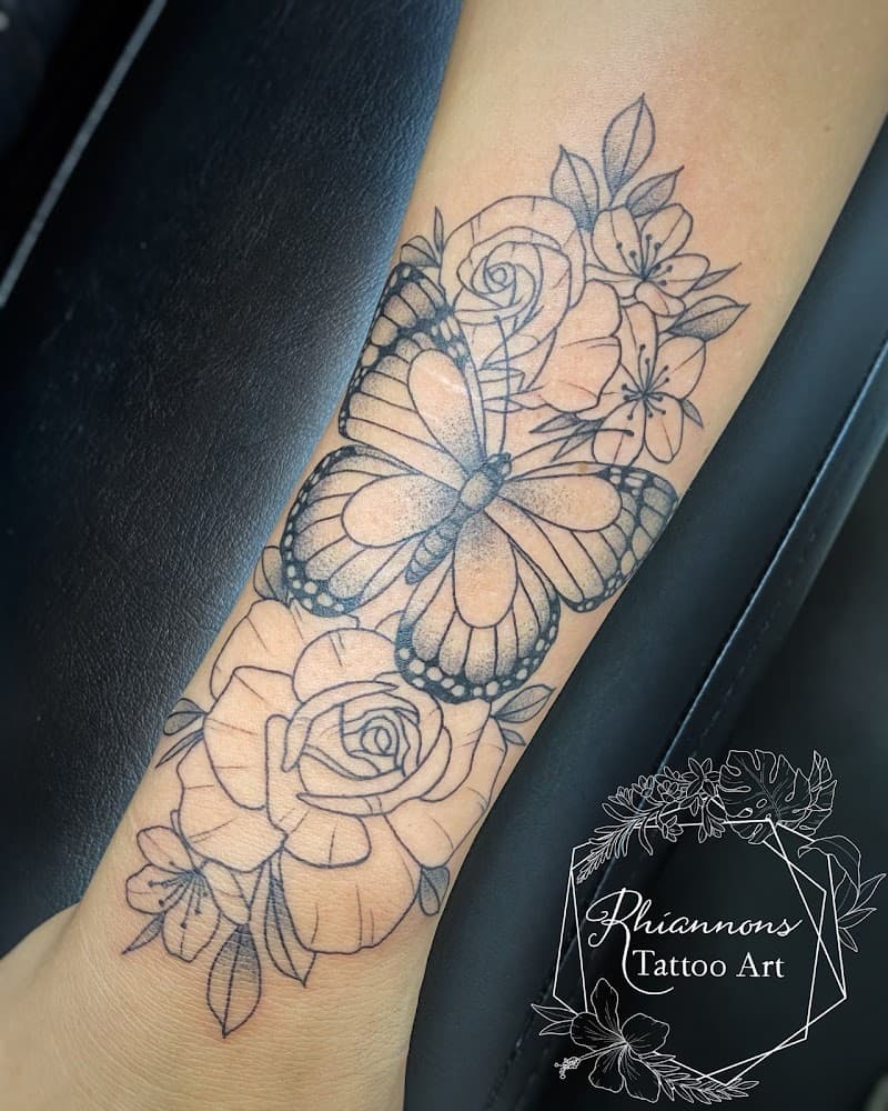 Fineline vlinder en bloemen op onderarm