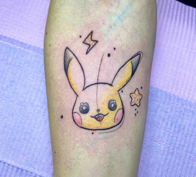 Schattige illustratieve Pikachu tattoo met bliksemschicht en ster op onderarm.