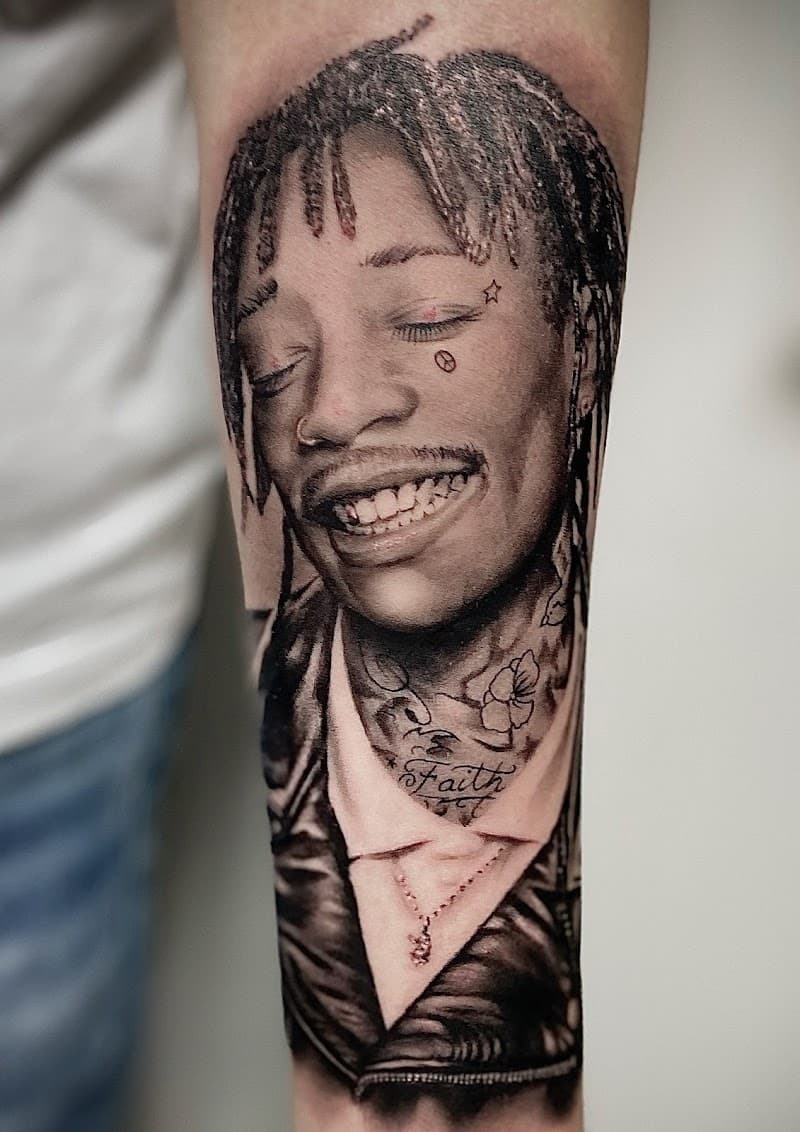 Realistisch zwart-wit portret van rapper Wiz Khalifa op de onderarm.