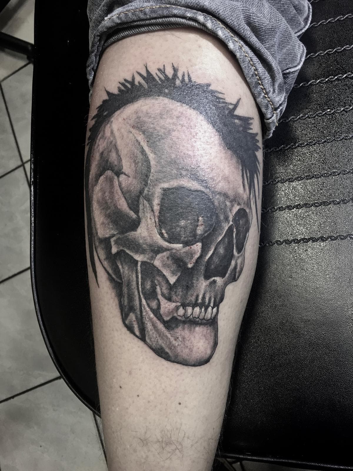 Realistische schedel met een hanenkam van stekels op het onderbeen.