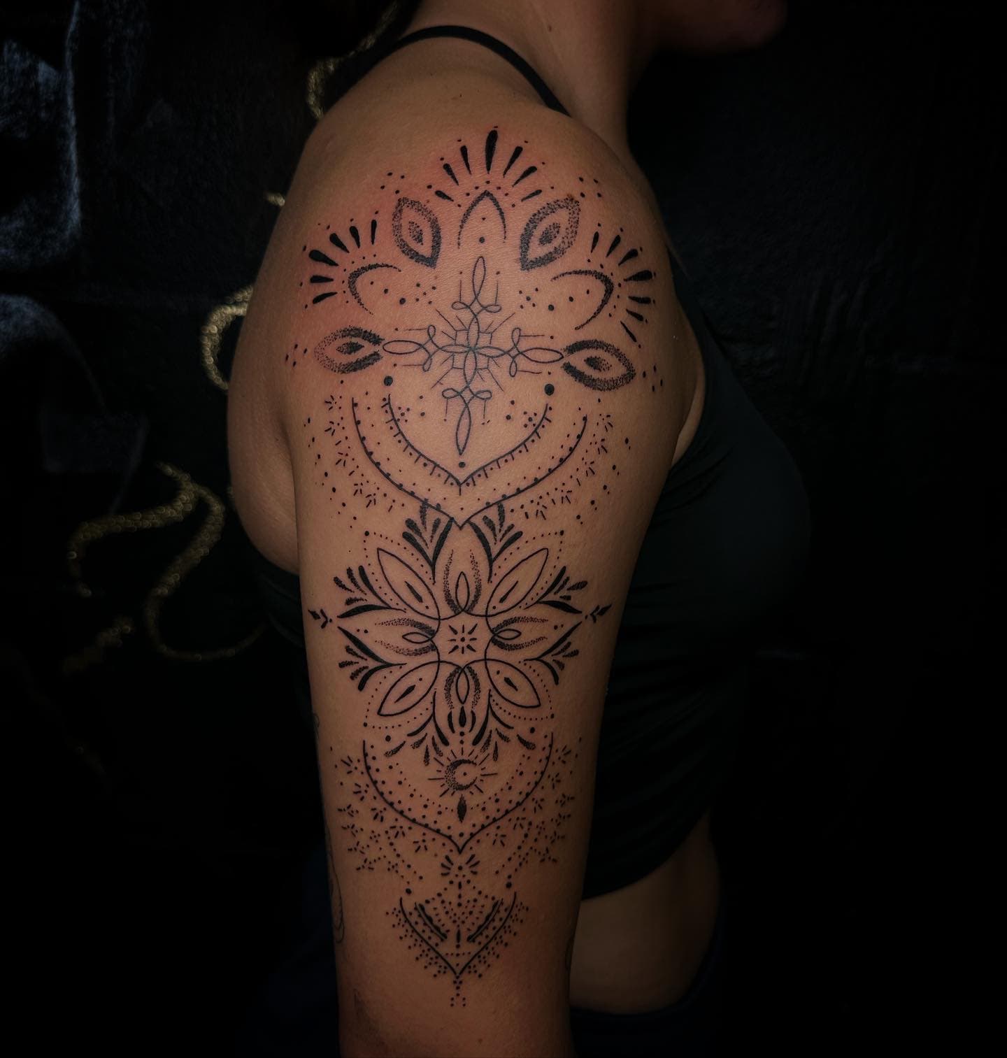 Grote mandala en ornamentale tattoo op bovenarm met dotwork en fineline.