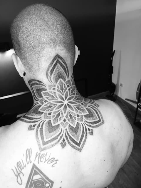 Grote dotwork mandala tattoo in de nek en op de bovenrug.