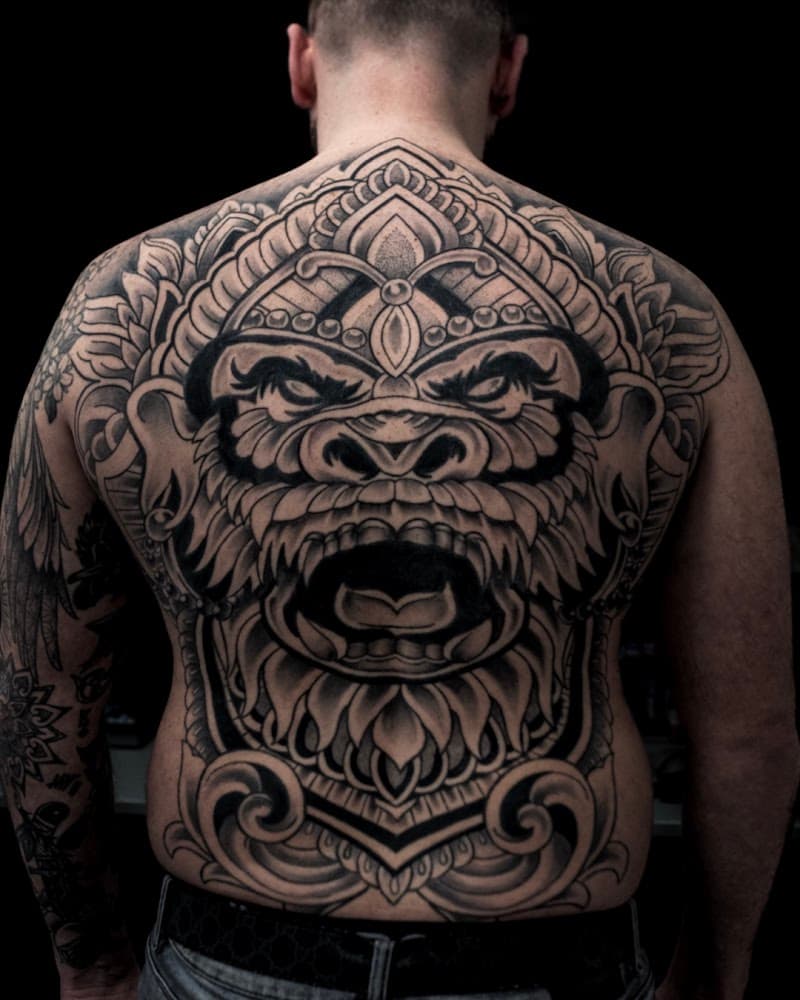Grote zwart-wit rugtattoo van een gorilla in een ornamentele, decoratieve stijl.
