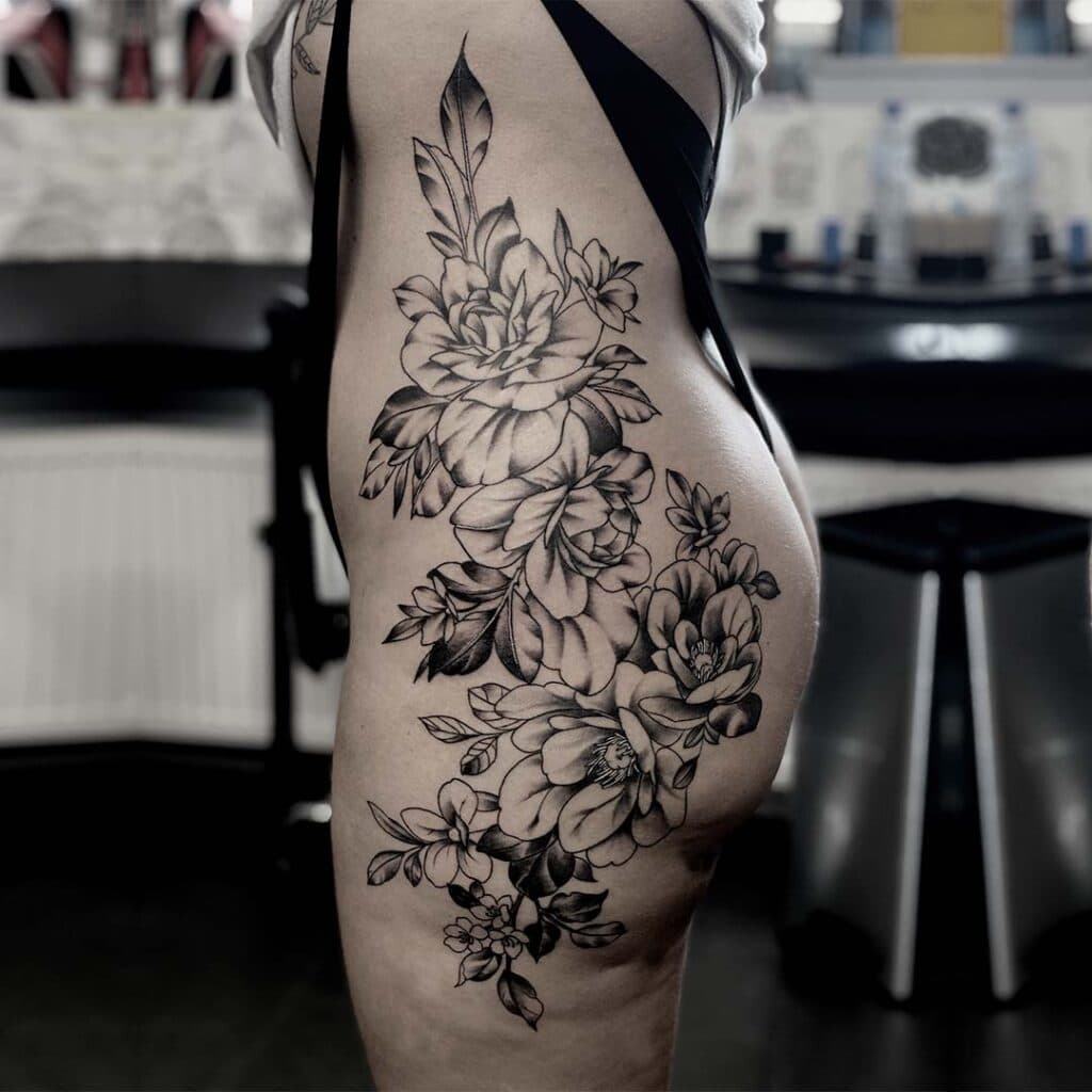 Groot zwart-wit bloemenstuk op heup en bovenbeen.