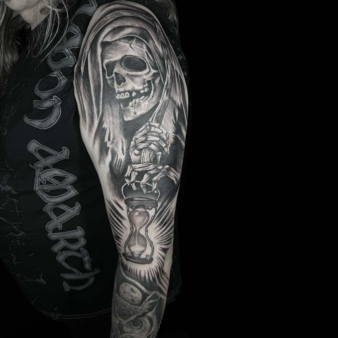 Realistische grim reaper met zandloper en uil op bovenarm.