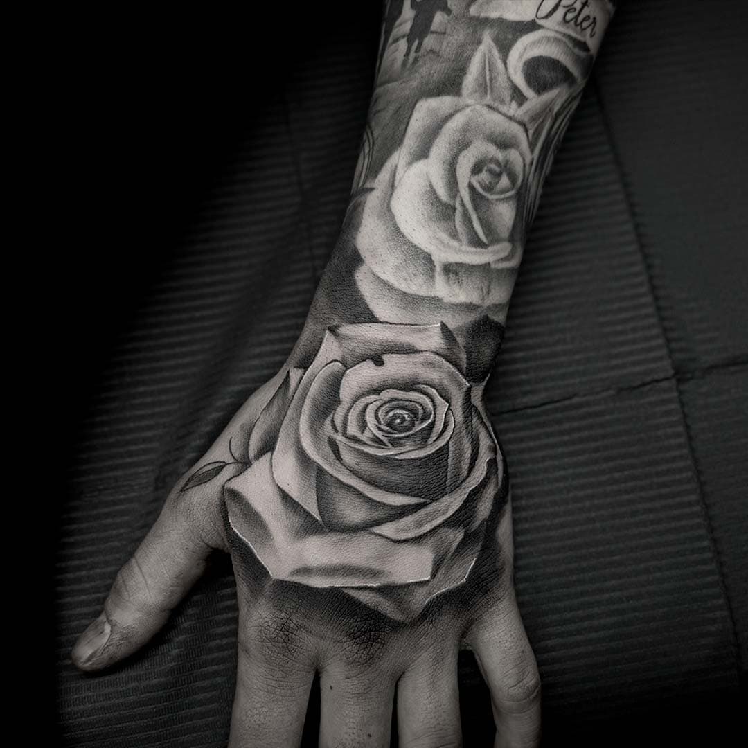 Realistische zwart-wit rozen op hand en onderarm.