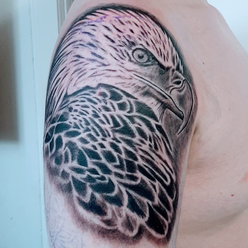 Zwart-wit realistische adelaar tattoo op bovenarm.