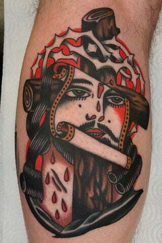 Traditional tattoo van Jezus aan het kruis met doornenkroon.