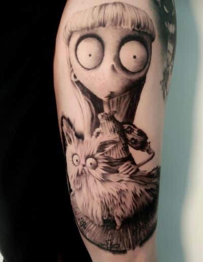 Zwart-wit tattoo van een Tim Burton-achtig meisje met een pluizige kat.