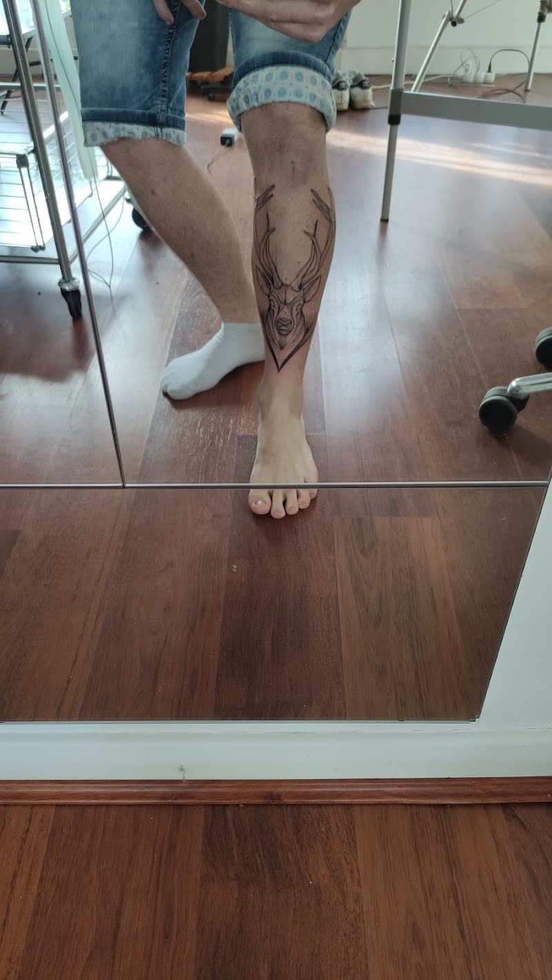 Geometrische hertenkop tattoo op het onderbeen.