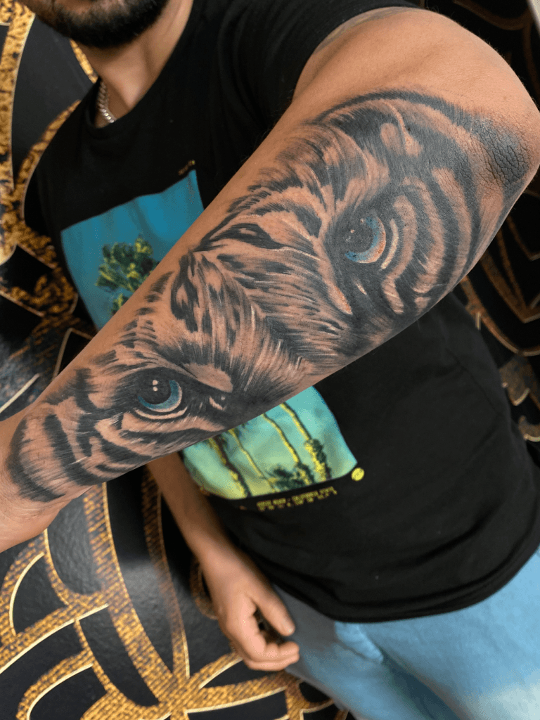 Realistische tijgerogen met blauwe ogen op onderarm.