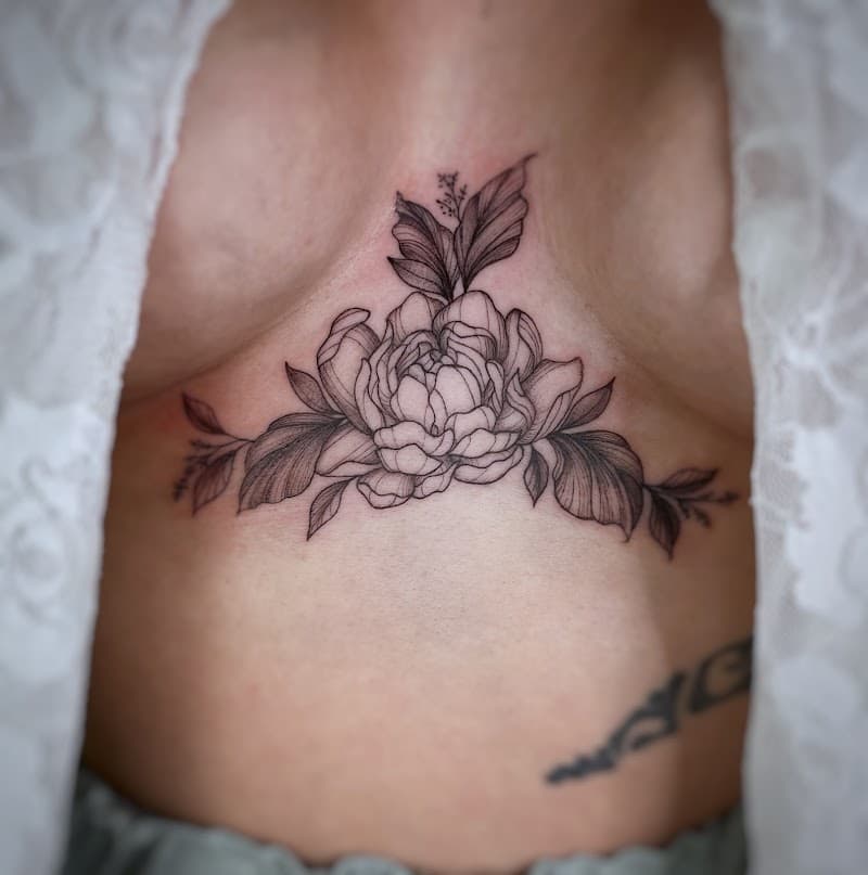 Fineline bloemen tattoo op het borstbeen.